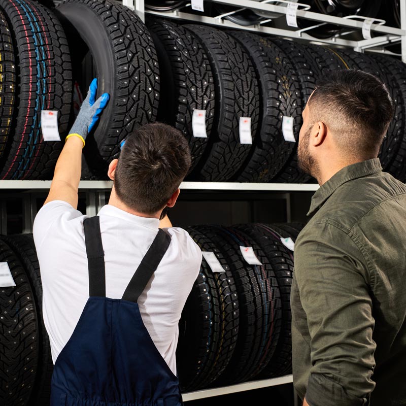 auto mechanic showing customer tires